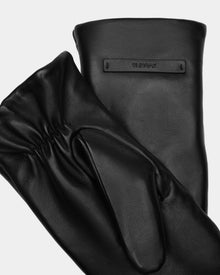 The SELMA - 8424508 Black womens leather mittens by Rudsak feature a smooth finish, an embossed rectangular brand patch on one glove, and gathered wrist stitching on the other—perfect for winter.