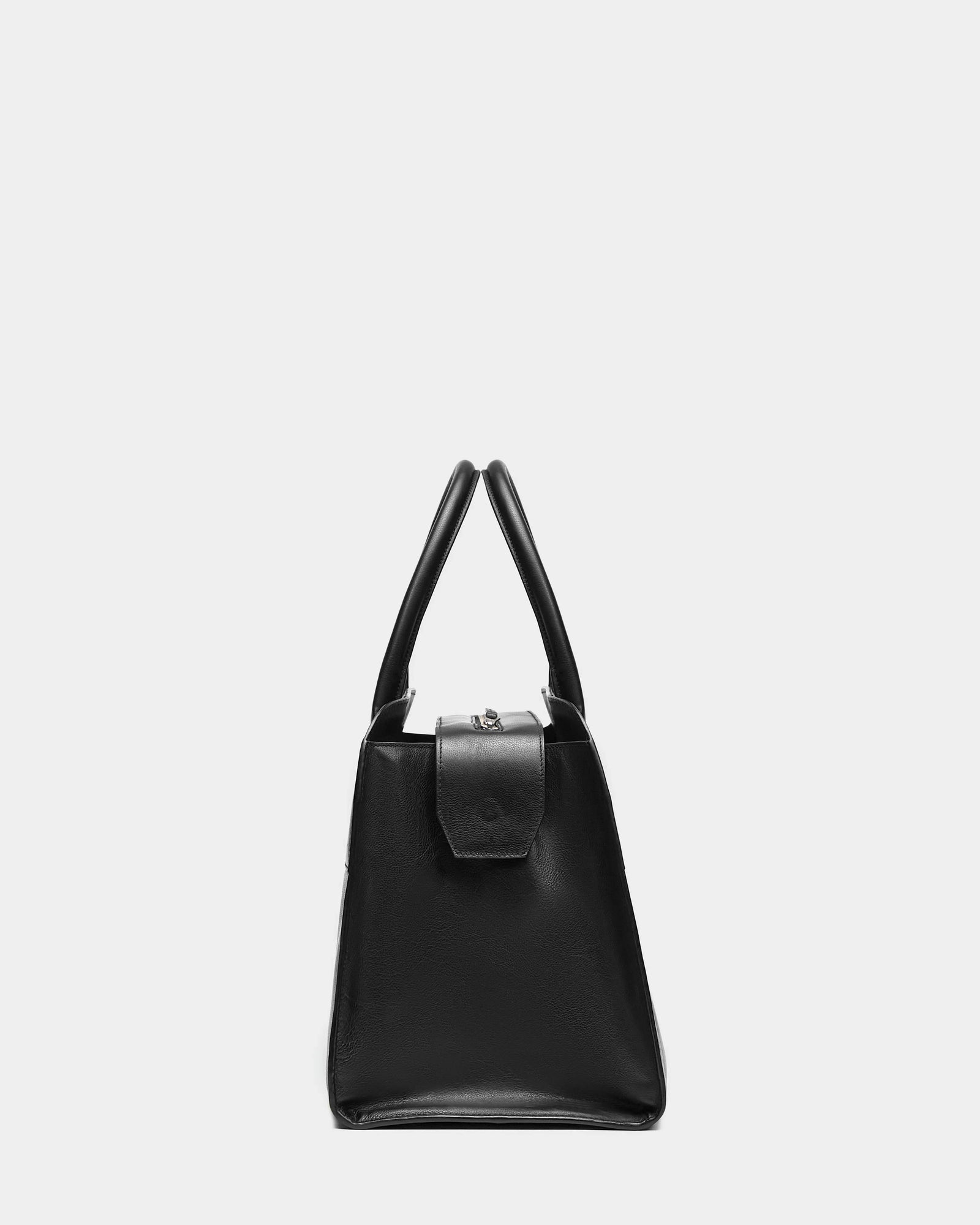 Side view of the Rudsak YASMINA L - 8324516 Black leather tote bag with structured handles and a flap closure, shown against a plain light gray background.