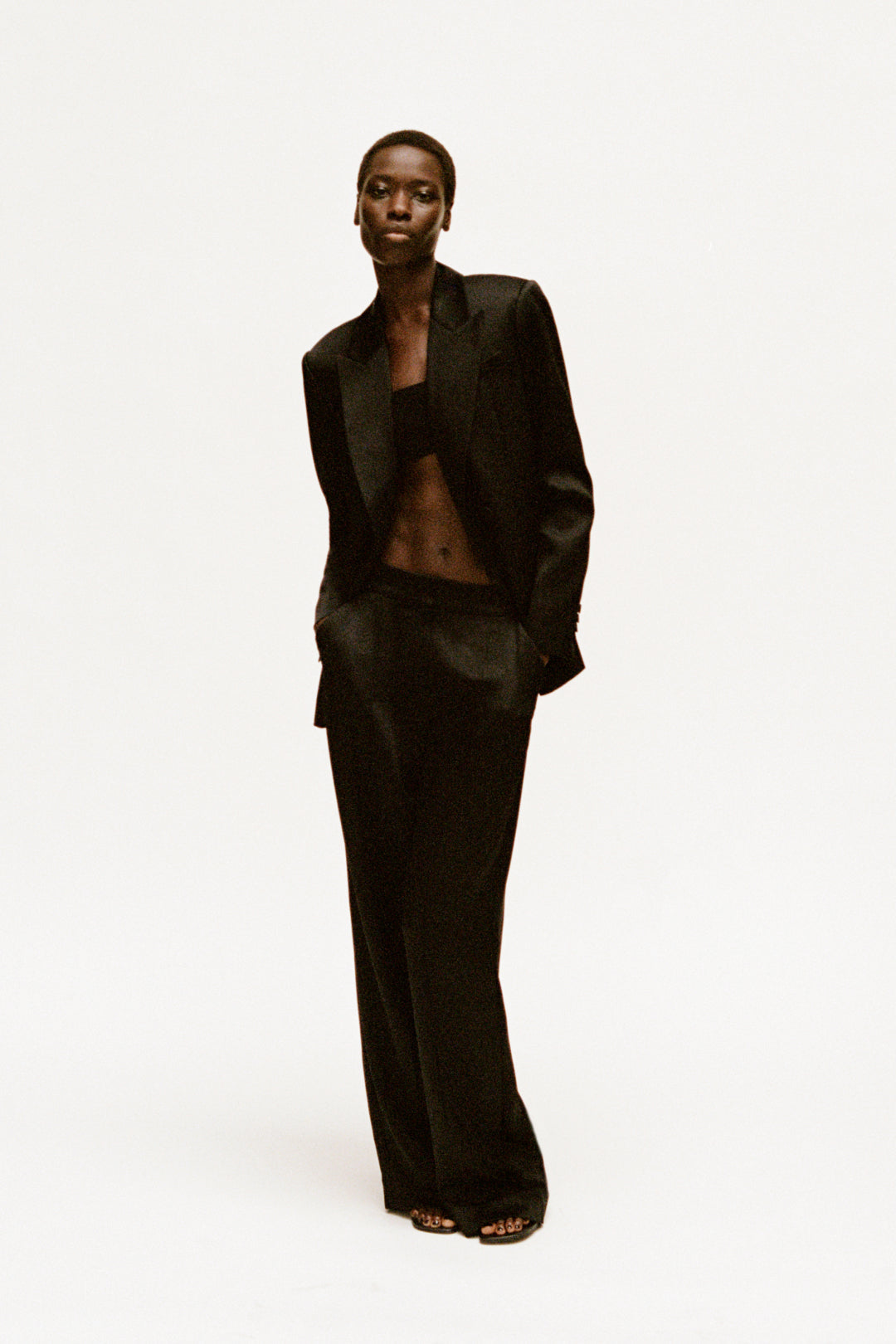 Black wide-leg pant with high waist and straight silhouette, styled with matching blazer.