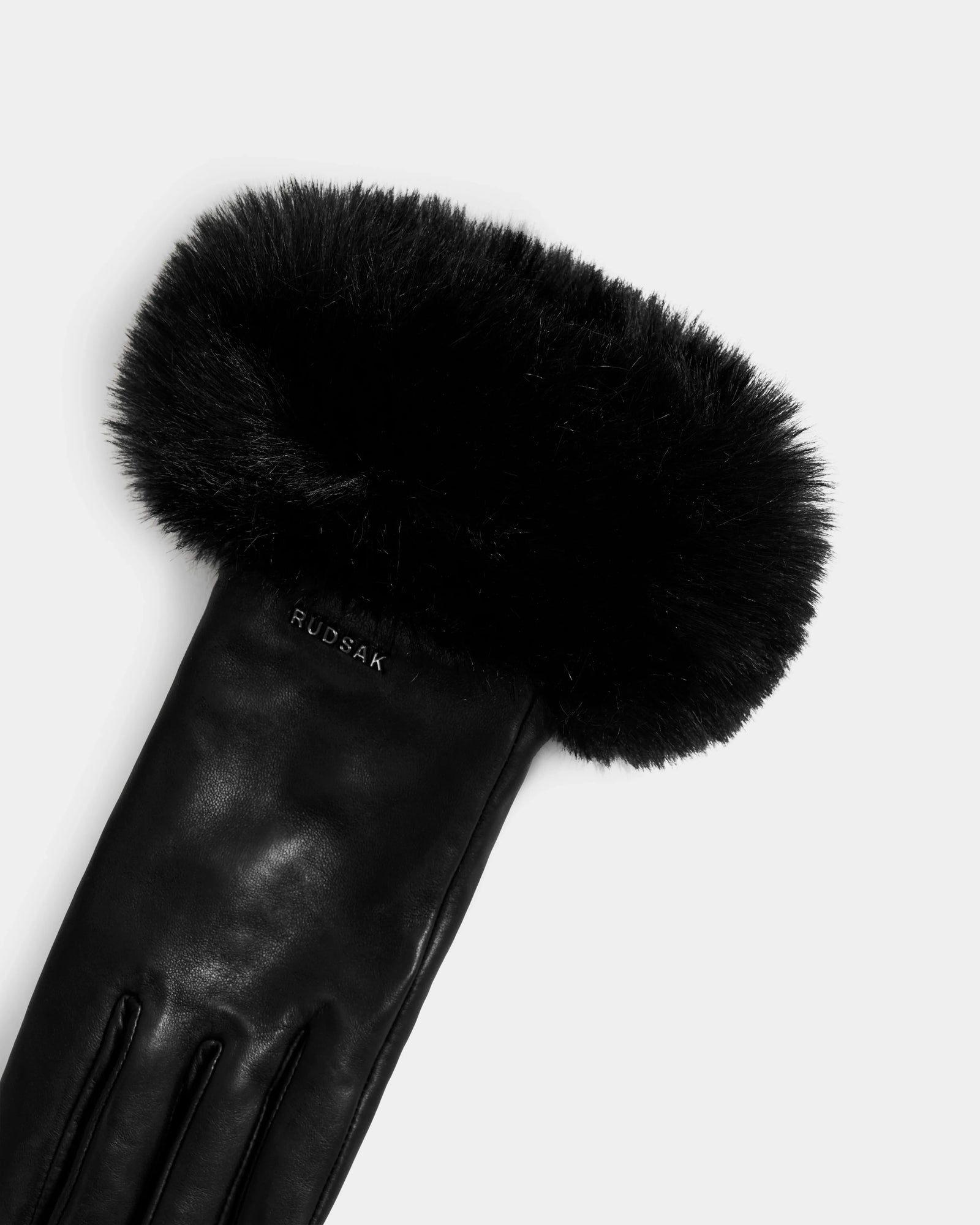The Rudsak GERRY - L425550 Black women’s leather glove, made from supple lamb leather, features a thick faux-fur cuff and an embossed brand name near the wrist. Shown on a plain white background.