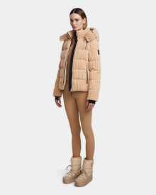 A woman wears the MIRRY FF - L124507 Iceland velvet corduroy puffer jacket by Rudsak with a hood, matching tan leggings, and beige lace-up boots, posed against a plain white background.