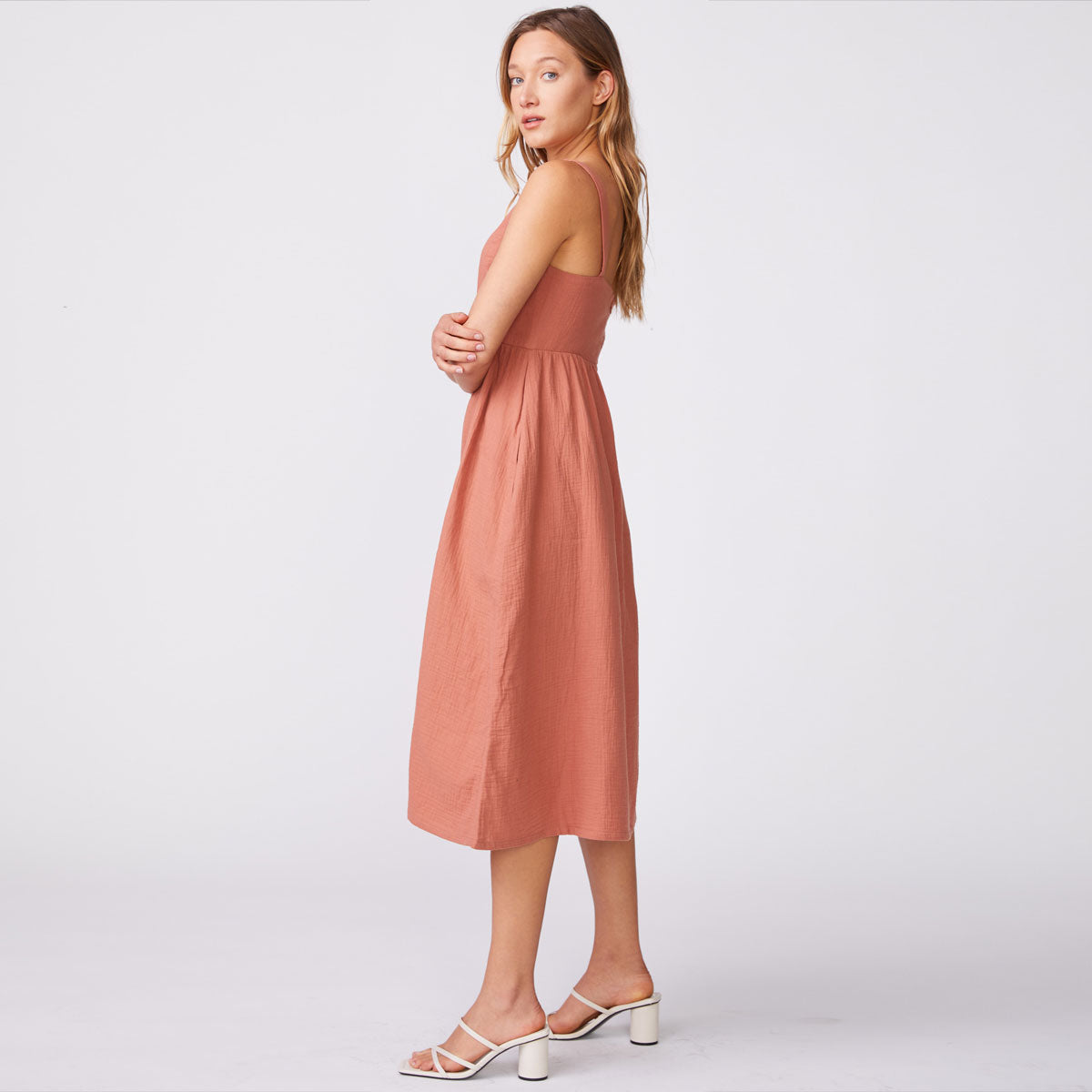 Side view of model wearing the gauze sleeveless maxi dress in faded rust.