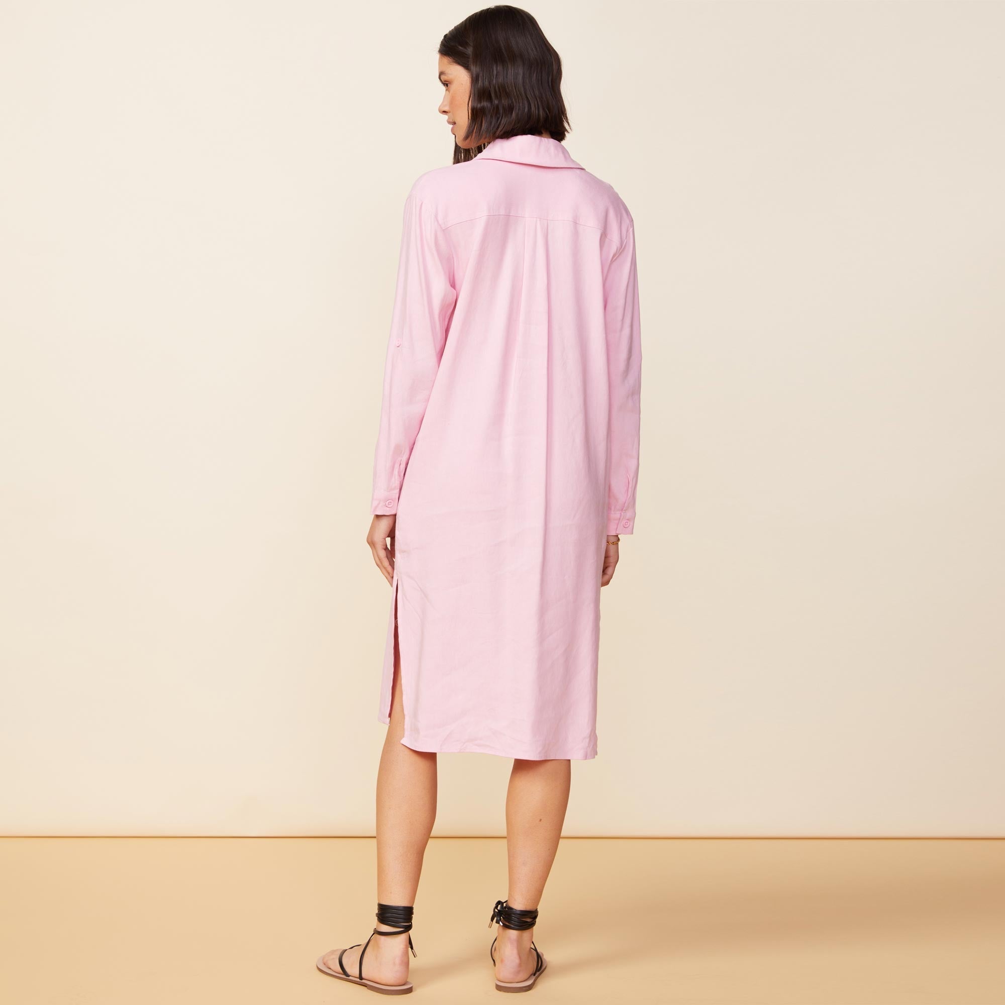 Back view of model wearing the linen shirt dress in bubblegum.