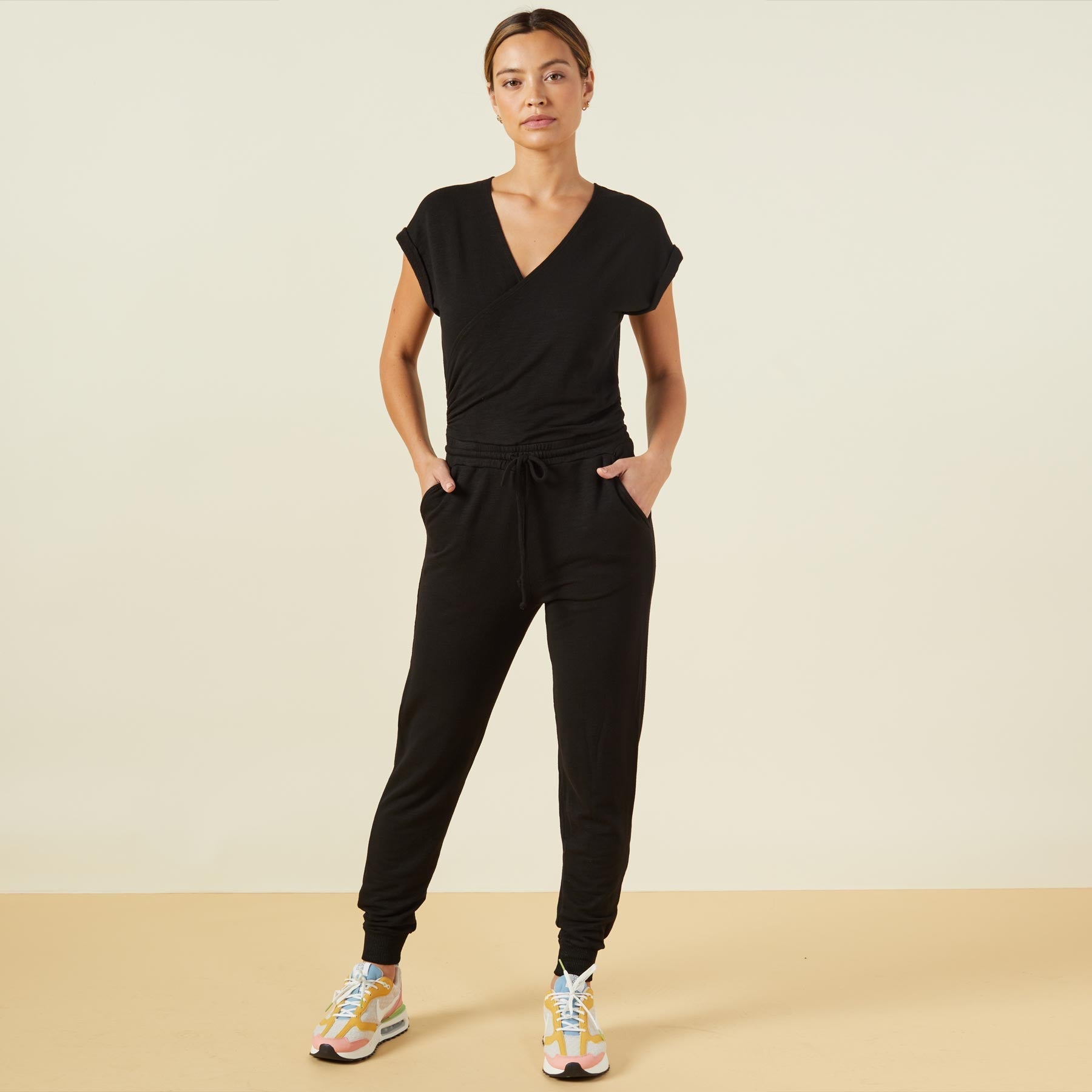 Front view of model wearing the supersoft wrapped jumpsuit in black.