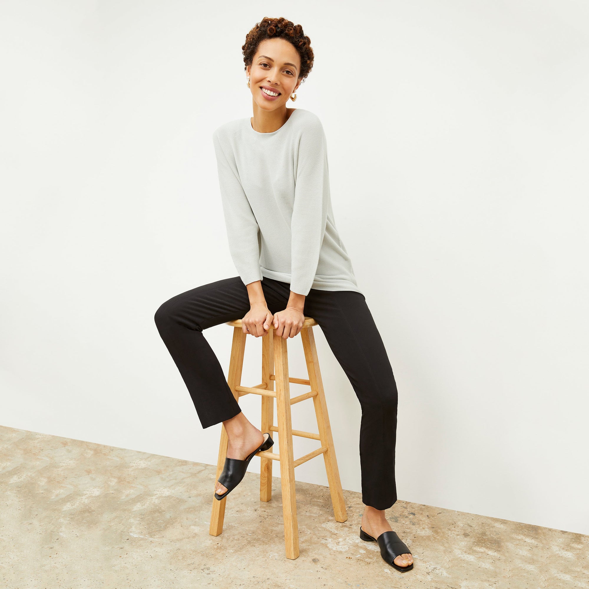 Front image of a woman standing wearing the Foster Pant—Everstretch in Black | Exclude