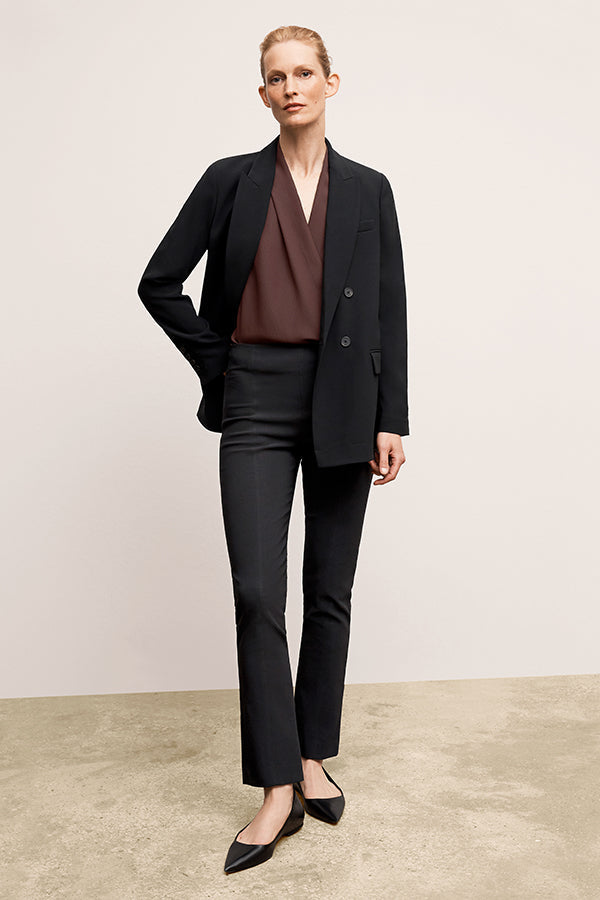 Front image of a woman standing wearing the Foster Pant—Everstretch in Black | Exclude