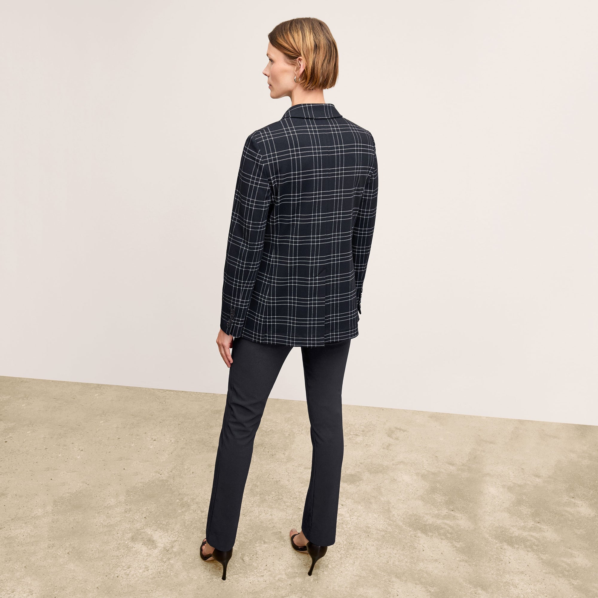 Back image of a woman standing wearing the Foster Pant—Everstretch in Black | Exclude