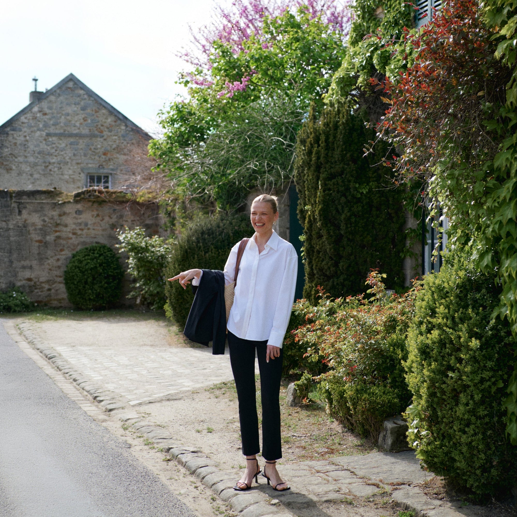 Person wearing black pants and a patterned top on a country road