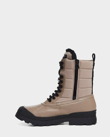 The REAGAN - 6222500 Cement by Rudsak is a men’s tan and black winter boot featuring a thick sole, front laces, side zipper, and padded sides—perfect for cold weather.