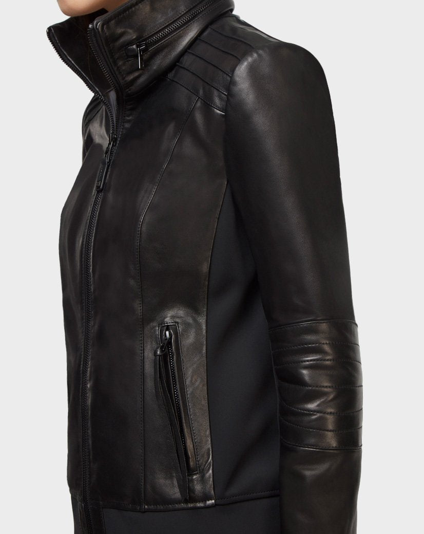 Someone models the Rudsak PRESLEY - CA EN 8119029 BLACK lamb leather biker jacket, featuring quilted shoulders and sleeves plus a zippered pocket, viewed from the side against a plain light background.