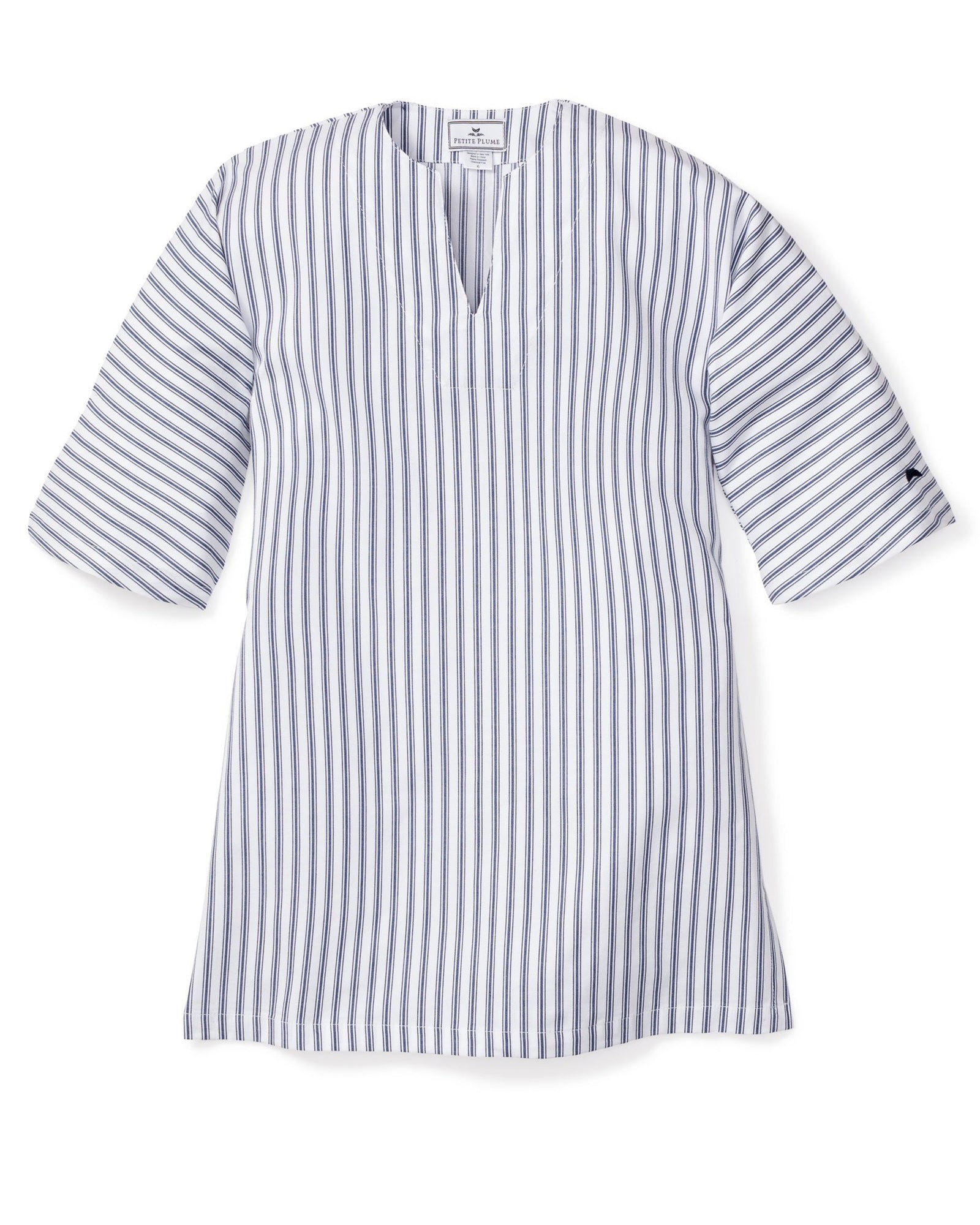 The Girls Twill Caftan in Navy French Ticking by Petite Plume is a blue and white vertical striped dress crafted from breathable cotton. It features elbow-length sleeves, a V-neckline, and a mid-thigh hemline, offering a tunic-like appearance reminiscent of luxurious sleepwear.