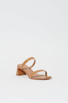 Tan debossed leather sandal with crossover straps and a chunky block heel.