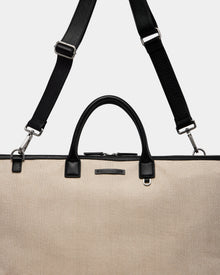 The Rudsak DUBLIN - 9324514 Vanilla is a beige textured canvas leather weekender tote with black handles and a detachable shoulder strap, ideal for travel. Unisex design, shown against a plain light background.