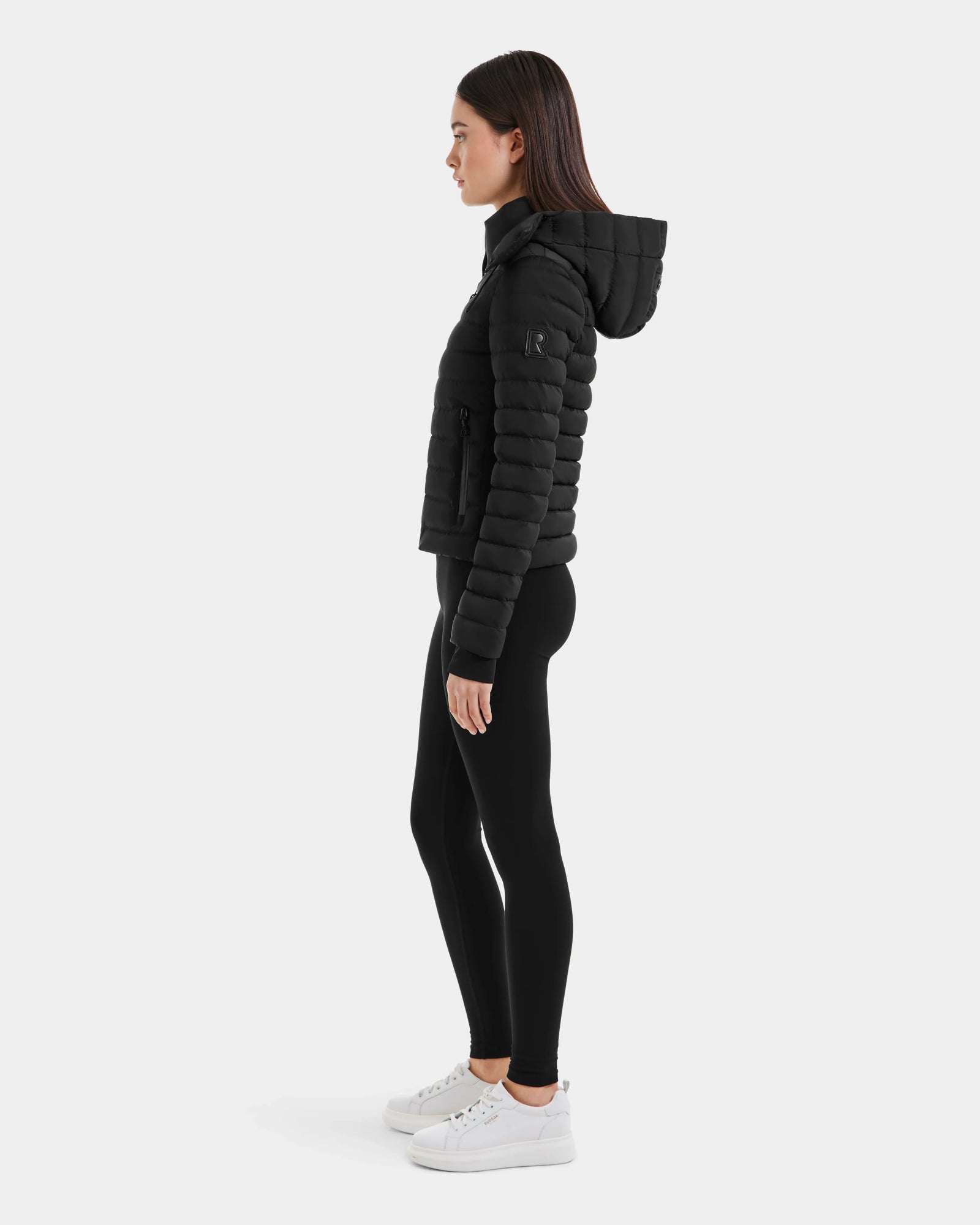 A woman wears the Rudsak MARYA M - L123559 Black womens down puffer.
