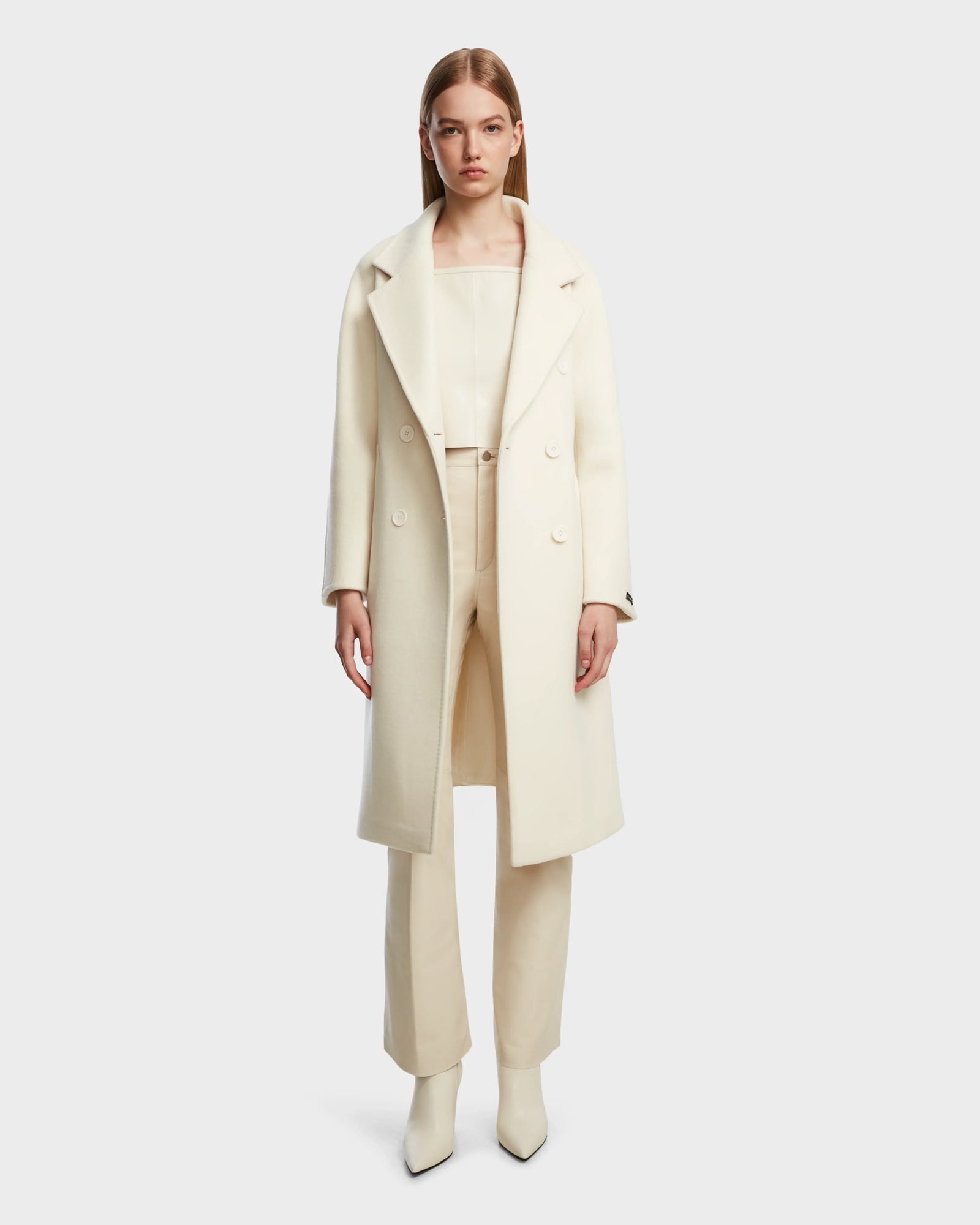 A woman faces forward against a plain white background, wearing the Rudsak KOURT W - 8124702 Iceland cream wool coat over matching light beige top, pants, and pointed-toe boots.