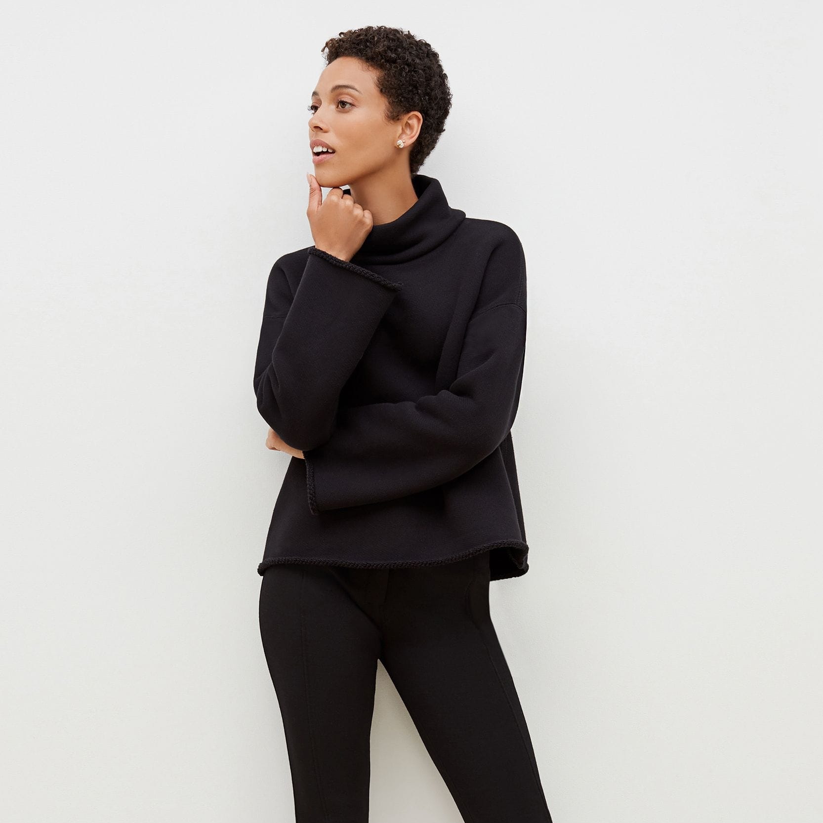 Front image of a woman standing wearing the Curie Pant--Worth in Black | Exclude