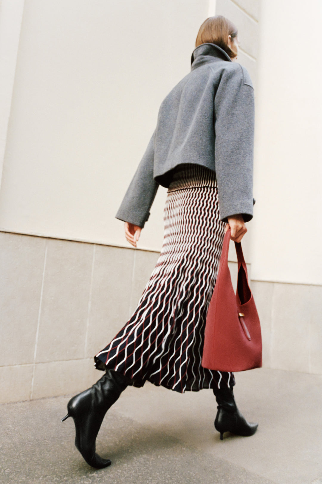 Light gray wool jacket with cropped fit and oversized collar, worn over black turtleneck.