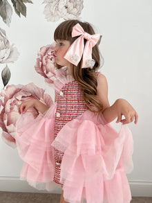 Girl wearing large clip on pink satin bow with flower embellishments