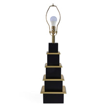 Black and gold lamp with a white light bulb on a white background